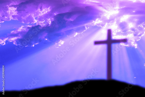 Cross on the Calvary hill with cloudy sky and sun light beams or rays. Abstract blury religious background. © t0m15