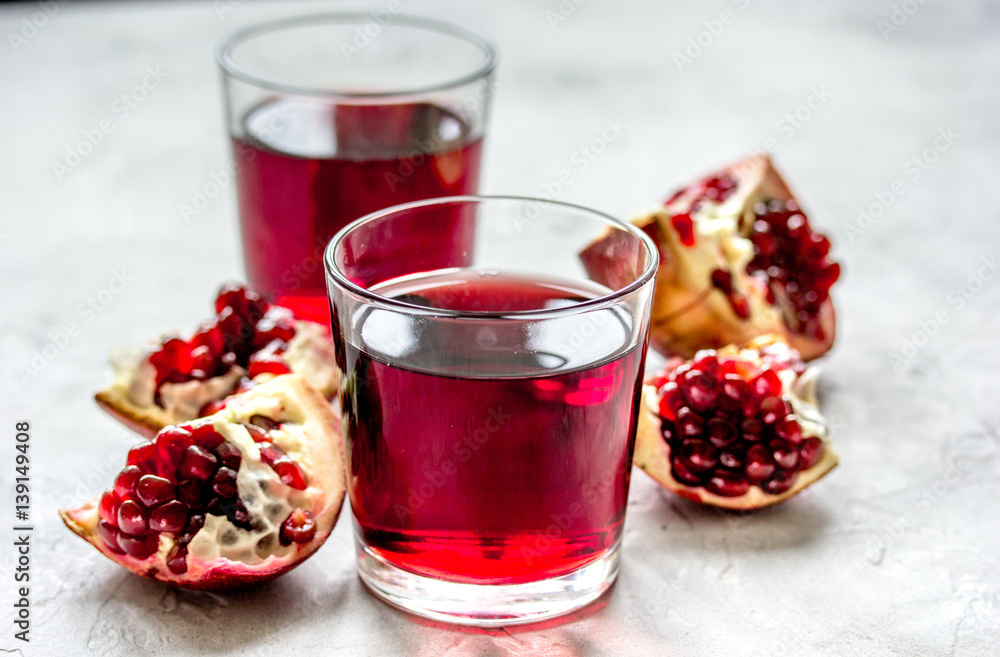 glass of pomegranate juice with fresh slices on stone background glass of pomegranate juice with fresh slices on stone background