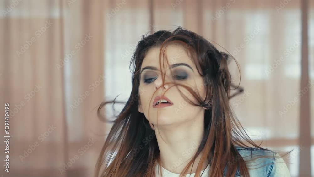 Look of pretty female dancer getting up and throwing her hair up. Slowly