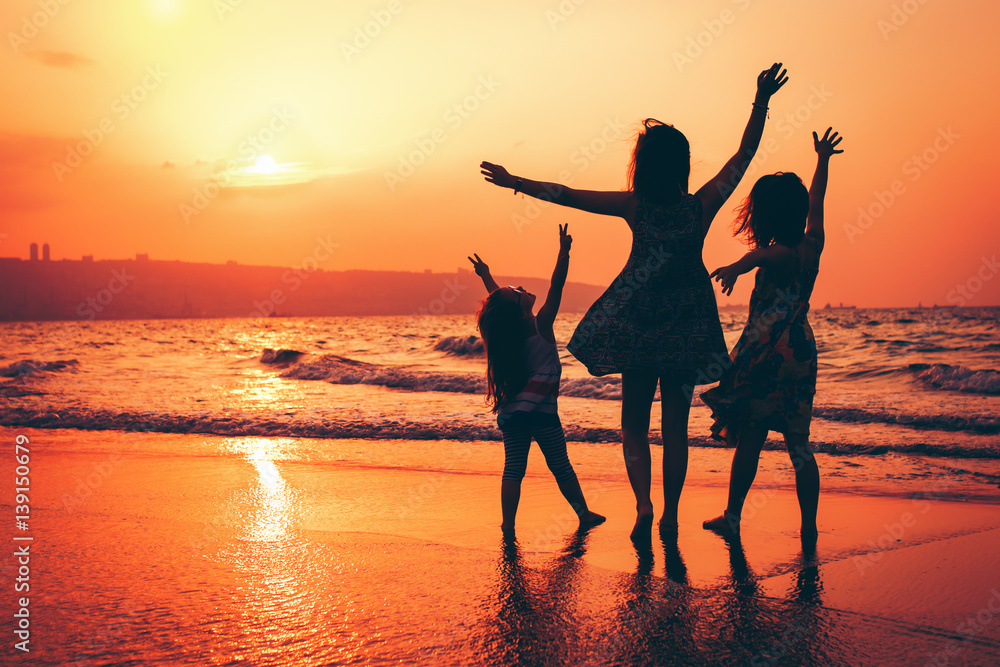 Fototapeta premium Sunset in Israel, happy sisters at the beach.