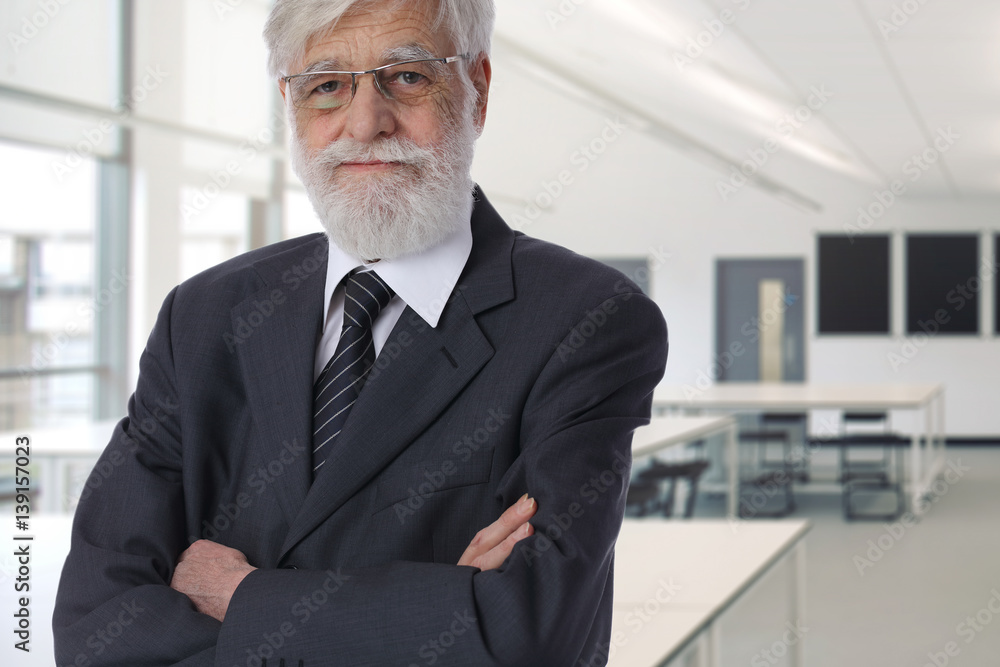 Portrait of smiling senior professor in classroom. Experience and education concept Portrait of smiling senior professor in classroom. Experience and education concept