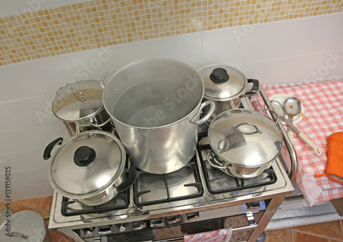 large and small pots in the industrial kitchen on the stove insi