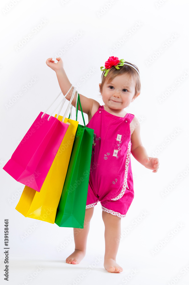 Little girl standing with colorful paper bags isolated on white background. Little girl standing with colorful paper bags isolated on white background.