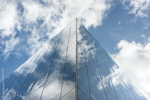 Looking up a reflections on glass covered corporate building