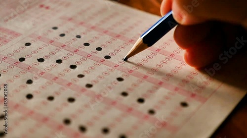 Student using pencil filling select choice on answer sheets slow motion shot