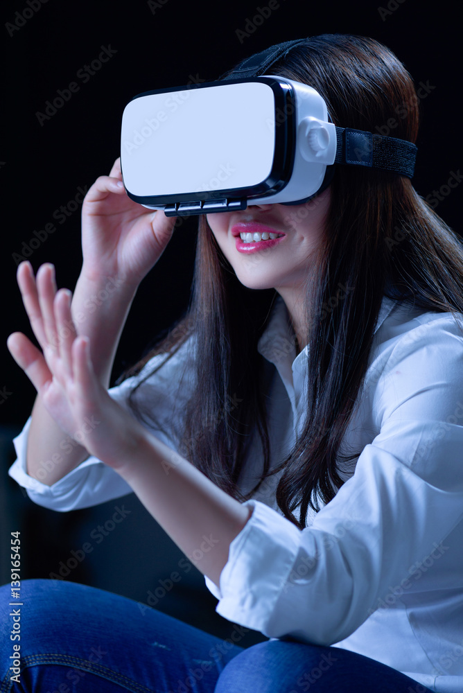 Asian Chinese young woman using vitual reality smart glasses in vitual space.low key photo Asian Chinese young woman using vitual reality smart glasses in vitual space.low key photo