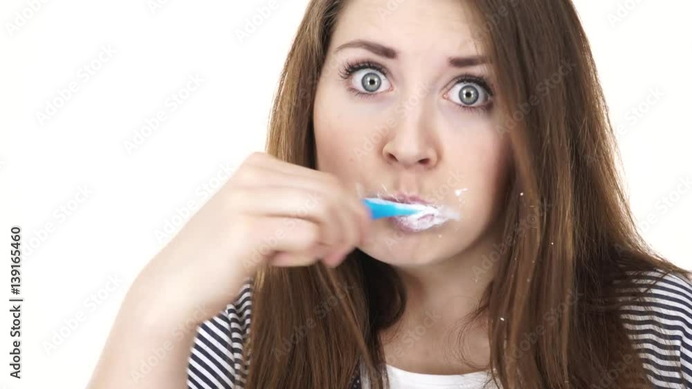 Woman dark long hair brushing cleaning teeth. Positive girl with toothbrush. Oral hygiene. Studio shot isolated on white background 4K ProRes HQ codec Woman dark long hair brushing cleaning teeth. Positive girl with toothbrush. Oral hygiene. Studio shot isolated on white background 4K ProRes HQ codec