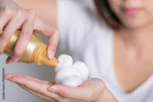 Close-up of hairdresser hairstylist female hand with hair mousse spray.