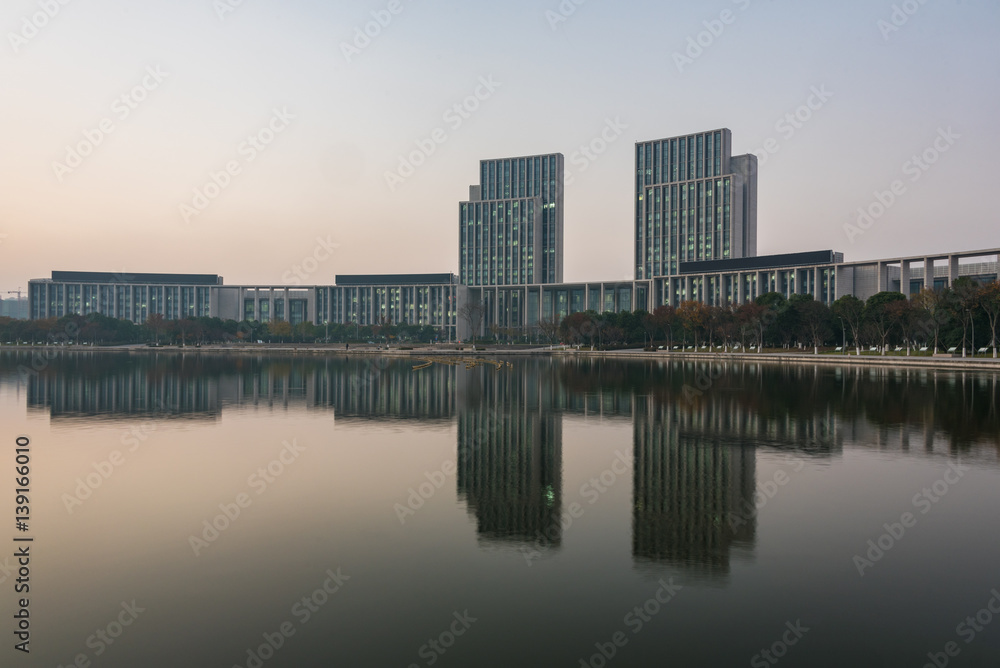 buildings standing by riverside under dramatic sky,wuxi city,jiangsu province,China.