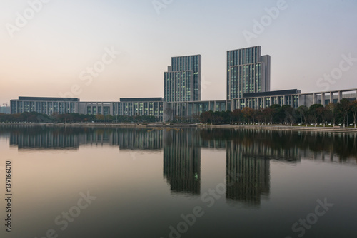 buildings standing by riverside under dramatic sky,wuxi city,jiangsu province,China.