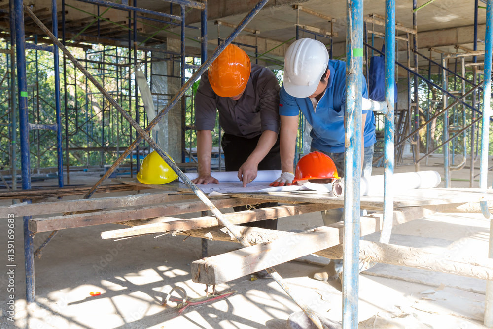 Fototapeta premium Construction concepts, Engineer and Architect working at Construction Site with blueprint