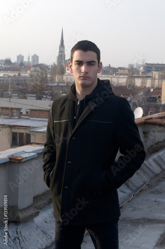 Photographing Danila Mazić with a black coat and black pants a background sunset in Novi Sad, Serbia photo