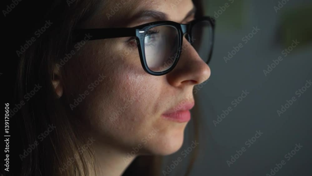 Woman in glasses looking on the monitor and surfing Internet Woman in glasses looking on the monitor and surfing Internet