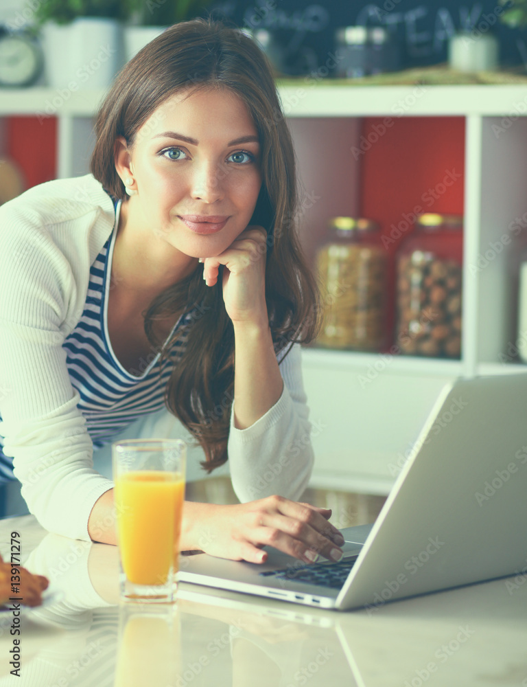 Young woman sitting near desk in the kitchen Young woman sitting near desk in the kitchen