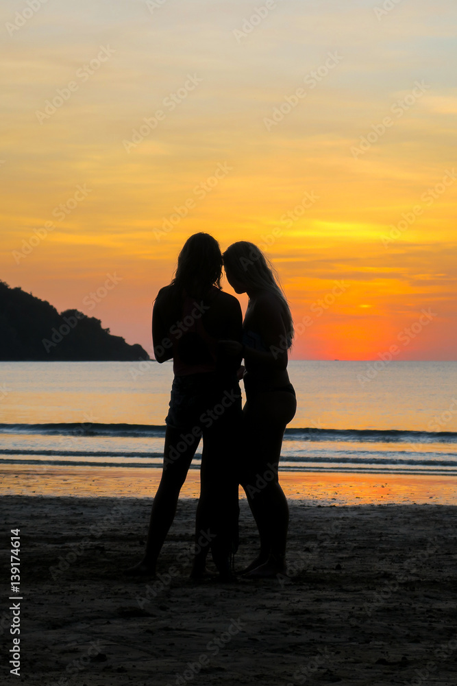 Two Sexy Girl Silhouettes During a Beach Sunset