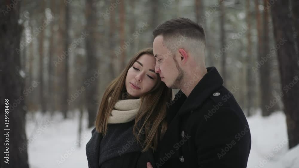 Man talking with his girlfriend in the winter forest and shows something around Man talking with his girlfriend in the winter forest and shows something around
