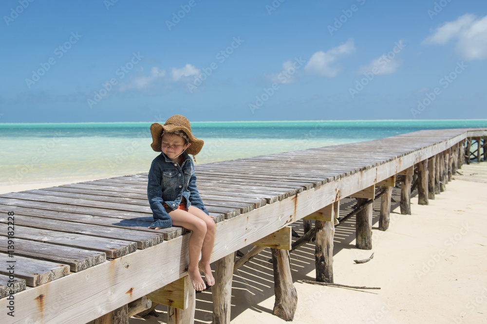 南の島の桟橋で座る女の子