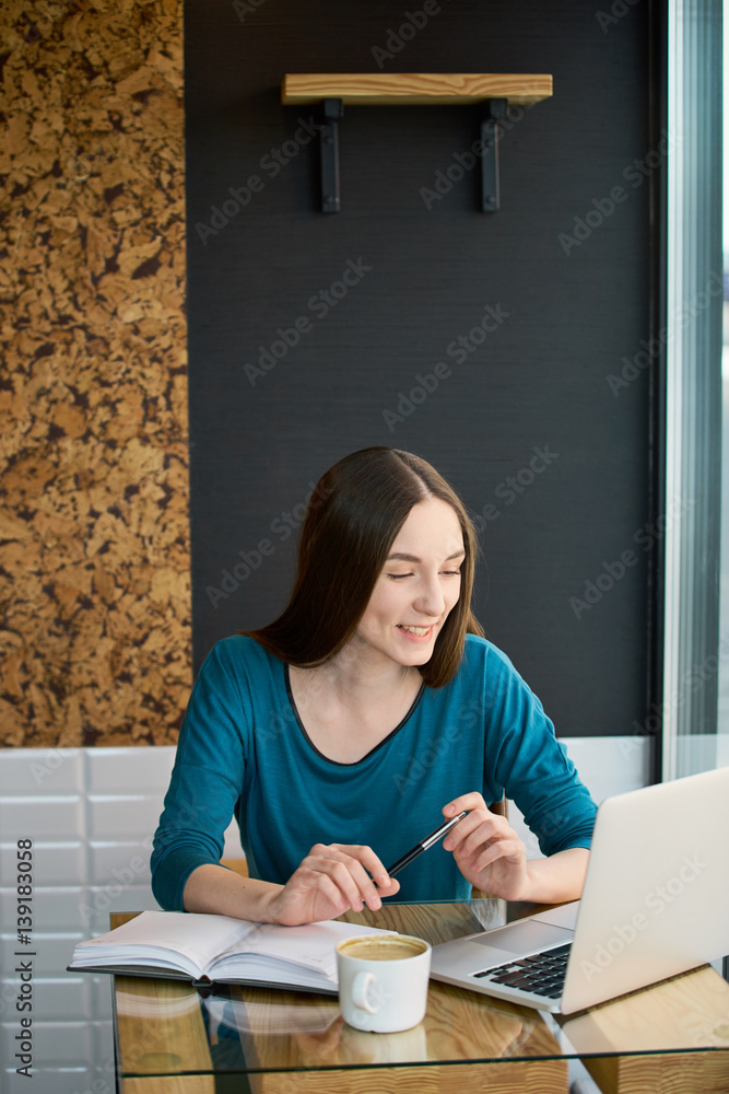 Naklejka premium Young woman working from the cafe