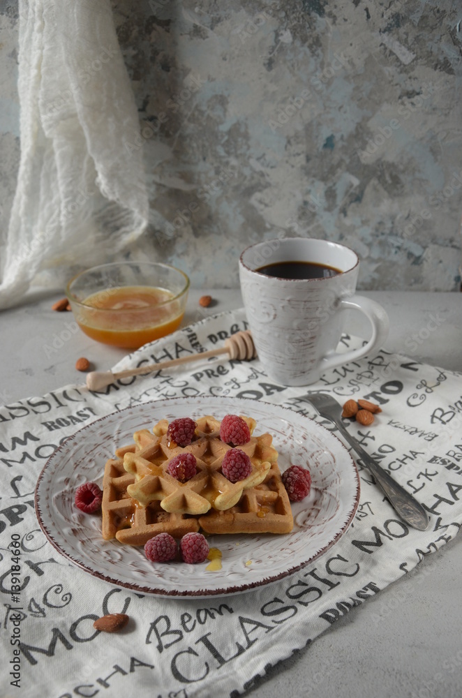 Belgian waffles with fresh raspberries, honey and cup of coffee