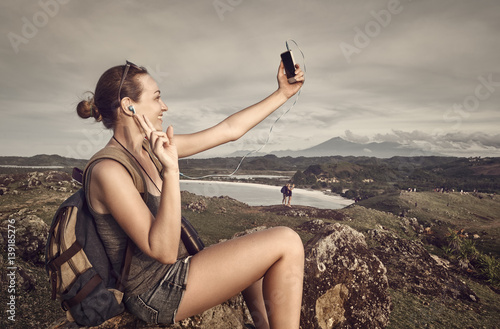 Fotografie attractive woman tourist with a backpack makes self-portrait