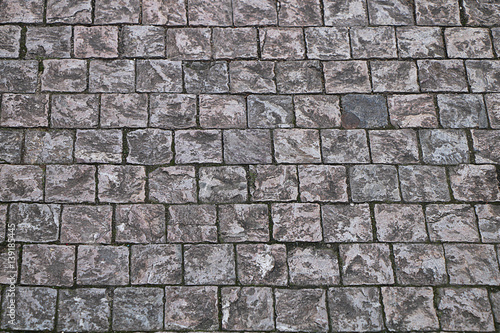 The texture of the stones and rubble on a street pavement.
