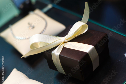 gift box with golden ribbon, glittery gold background photo