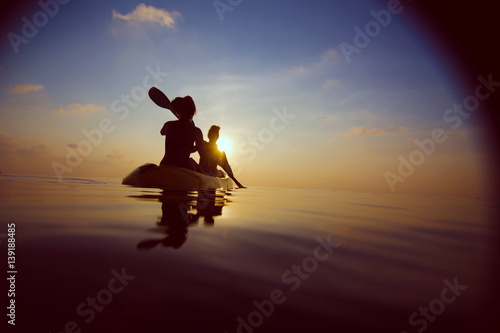 silhouette of people kayaking at sunset