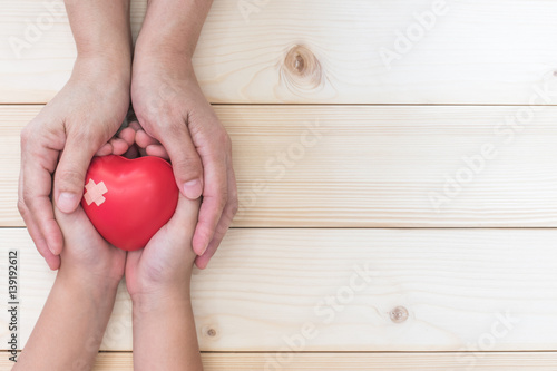 Mom mother's hand holding daughter son child kid palm support red heart love bal Fototapete