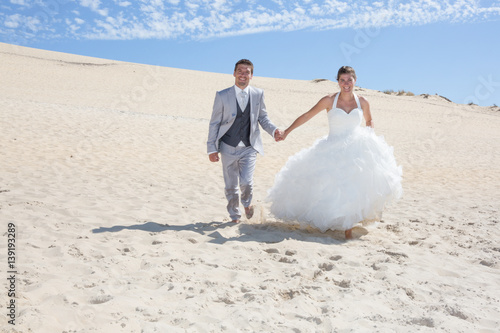 couple of married walk on the sand dune at the beach