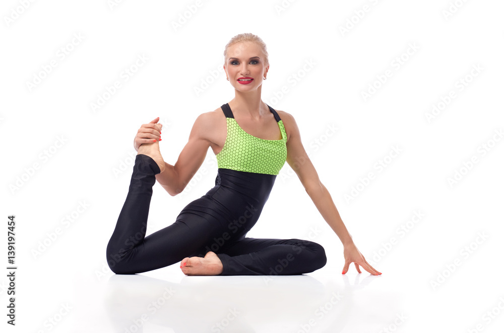 Gorgeous young woman practicing yoga sitting on the floor 