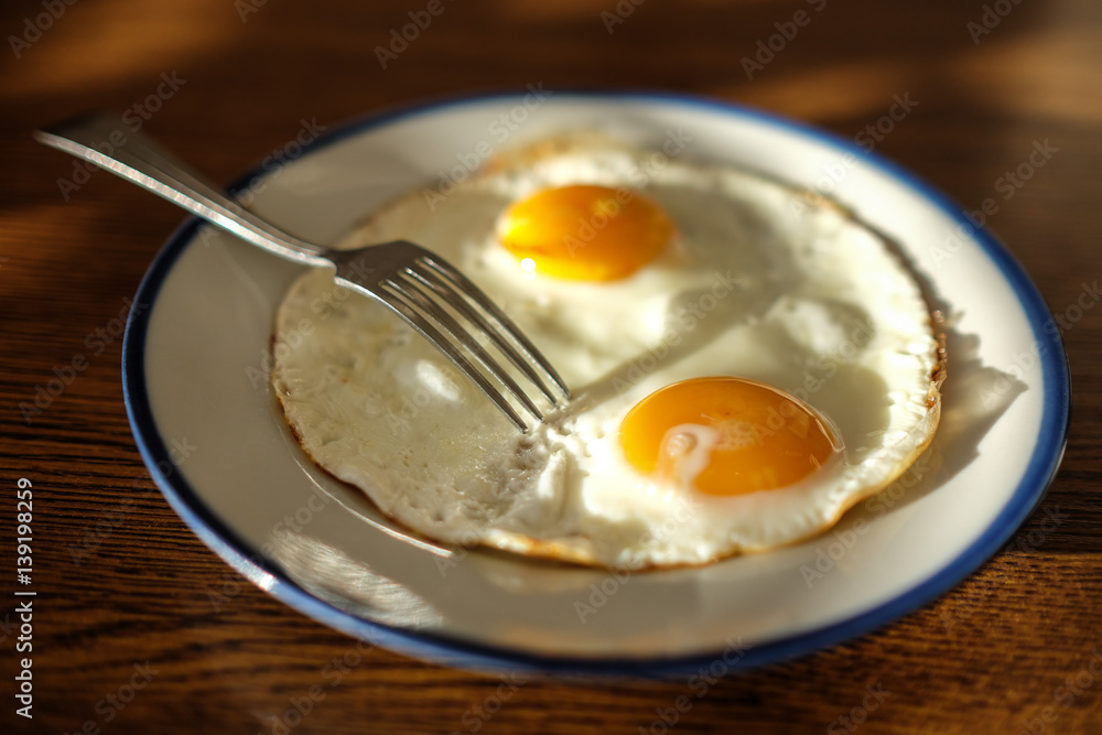 Two fried eggs on the tray with the light blue platter Two fried eggs on the tray with the light blue platter