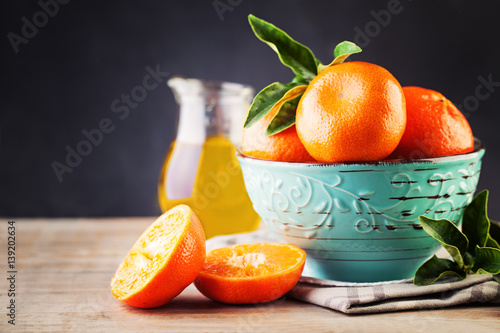 Ripe Mandarin Fruit  and Green Leaves on Old Rustic Wooden Board Background