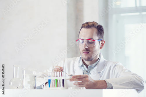 chemist interferes with a substance in a Petri dish photo