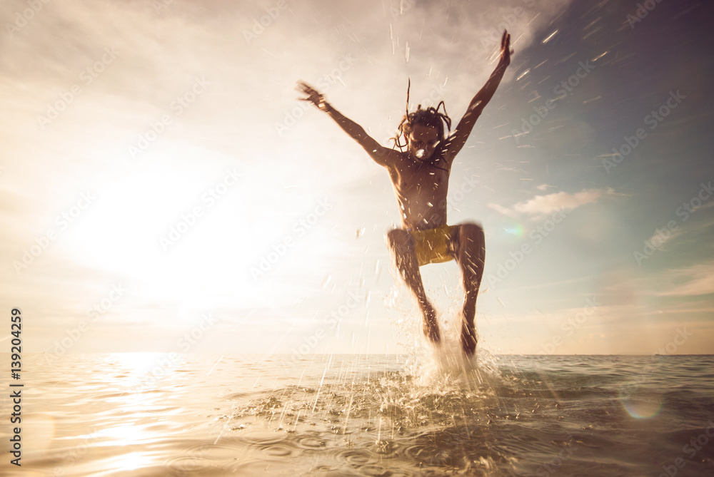 young man jumping in the sea