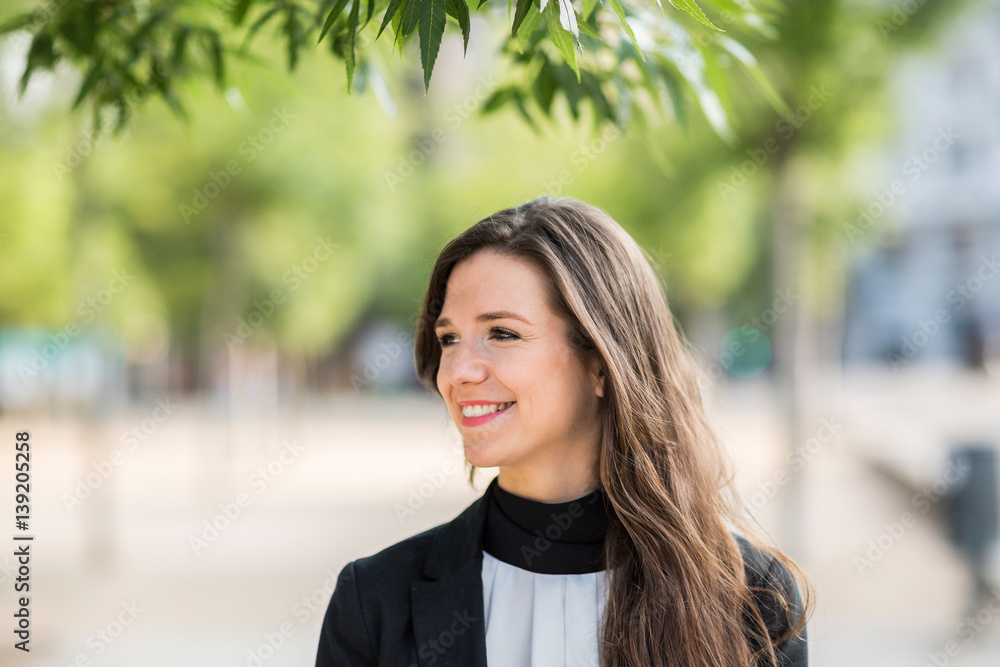 Smiling businesswoman under the tree