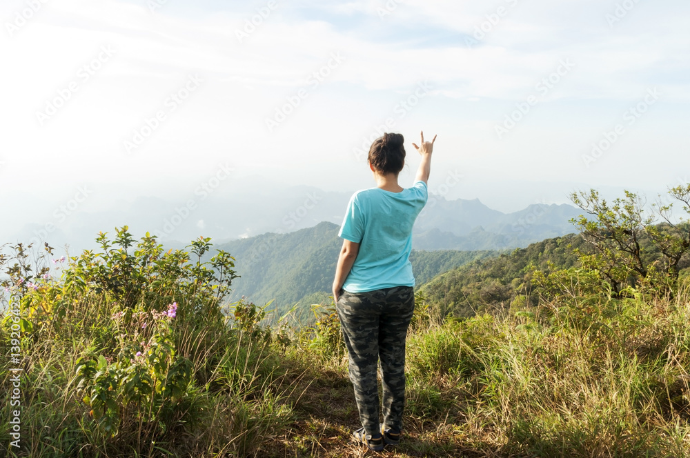 woman stand on top mountain and see view at sunny day. subject is soft focus woman stand on top mountain and see view at sunny day. subject is soft focus
