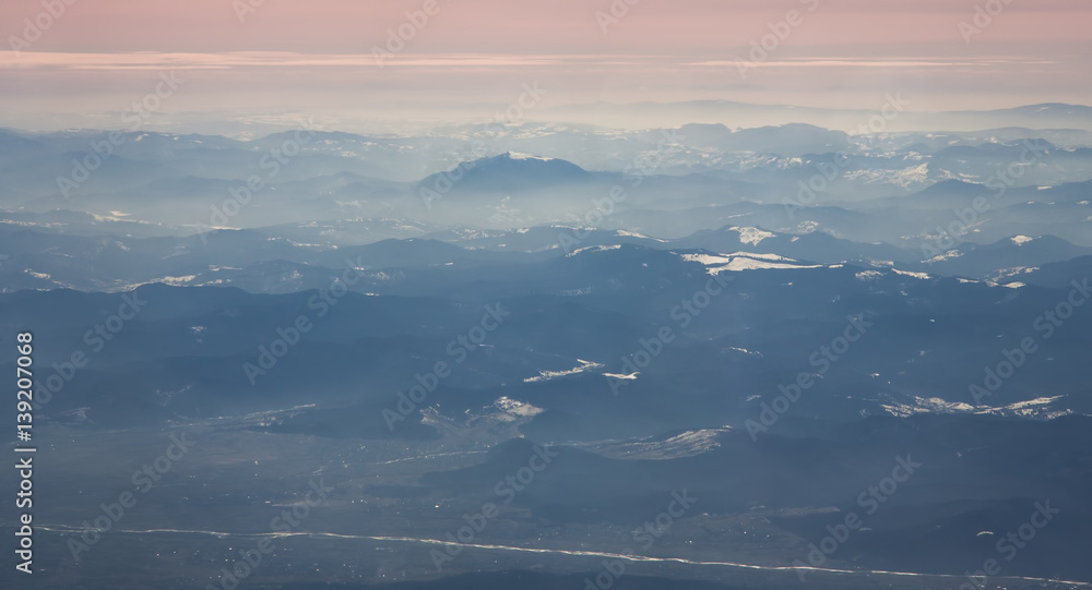 Aerial view of Ceahlau Massif and surrounding mountains in Romanian Carpathians from airplane. North view Aerial view of Ceahlau Massif and surrounding mountains in Romanian Carpathians from airplane. North view