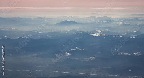 Fototapeta Naklejka Na Ścianę i Meble -  Aerial view of Ceahlau Massif and surrounding mountains in Romanian Carpathians from airplane. North view