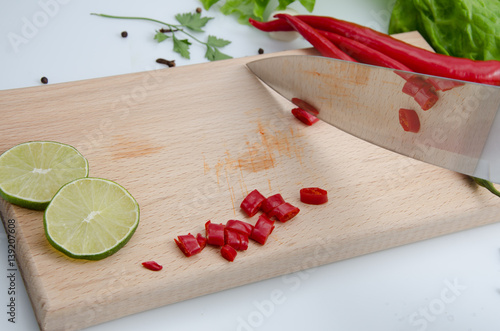 Pepper is reflected from the knife, wooden board, llime photo