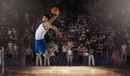 basketball player jumping with ball on stadium