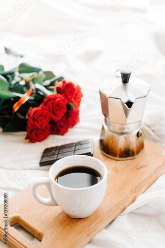 A cup of coffee, coffee on the wooden Boards, a bouquet of red roses on a white background