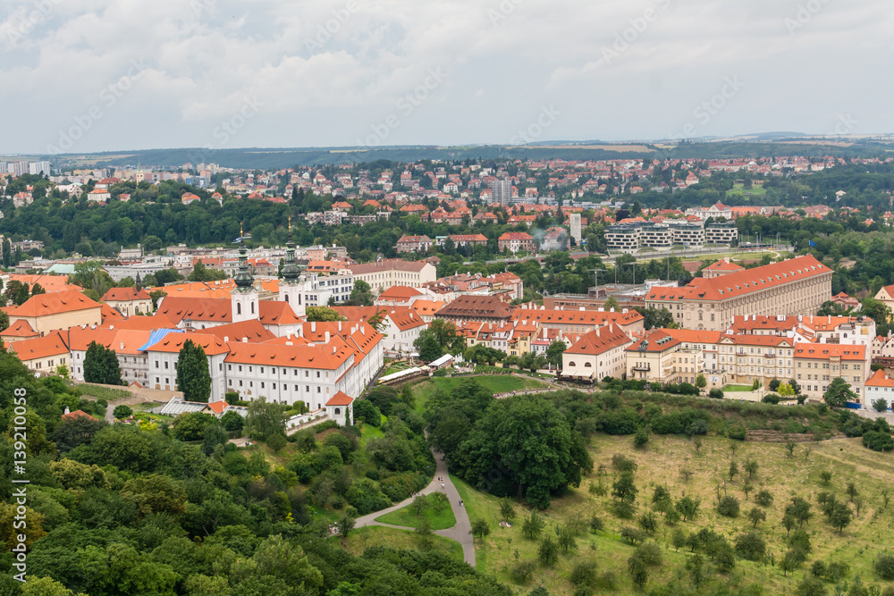 Obraz premium Top view to old town, historical districts and red roofs of Prague, Czech republic from an observation deck on Petrin hill.