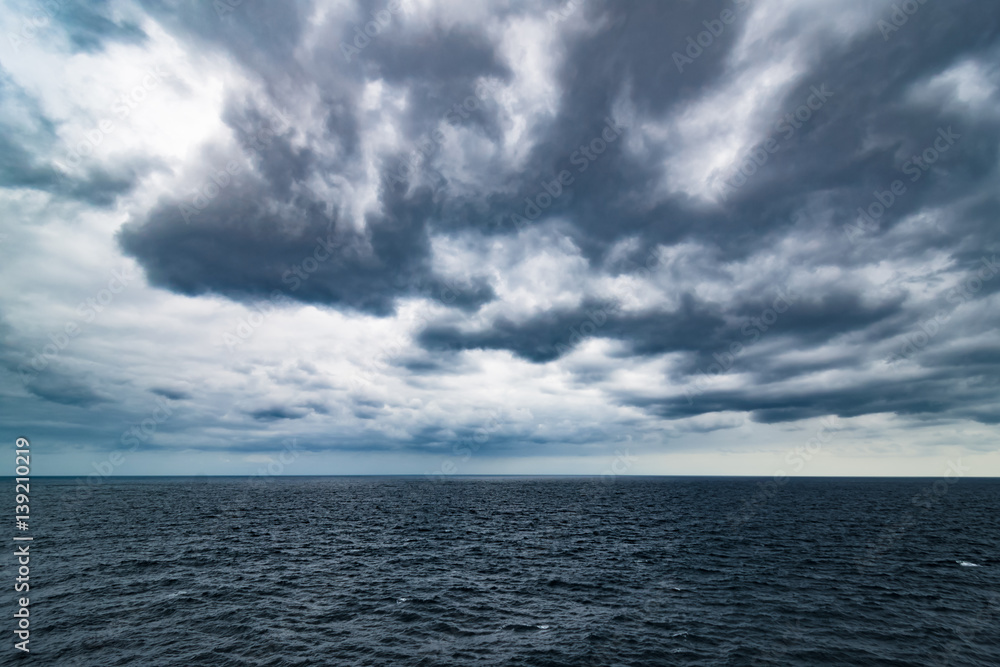 Atlantic Ocean with dramatic blue sky and clouds behind cruiser Atlantic Ocean with dramatic blue sky and clouds behind cruiser