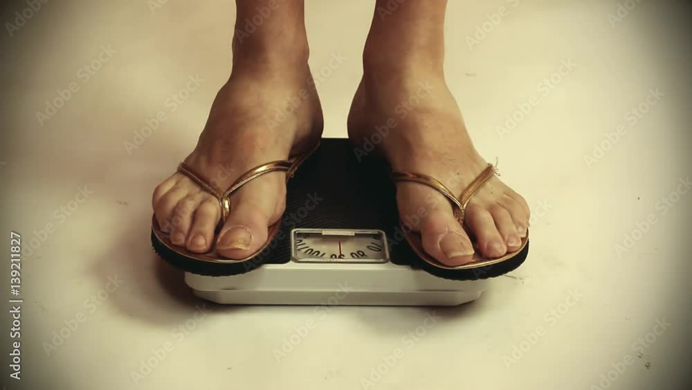 Overweight woman on a scale. Lifestyle and healthcare footage. Overweight woman on a scale. Lifestyle and healthcare footage.