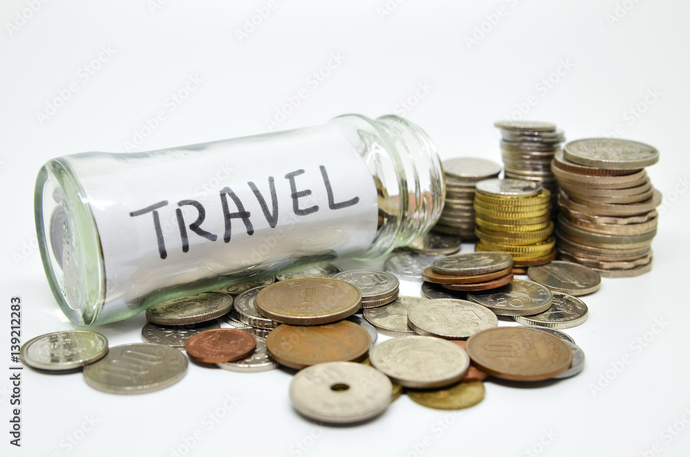 Travel lable in a glass jar with coins spilling out Travel lable in a glass jar with coins spilling out