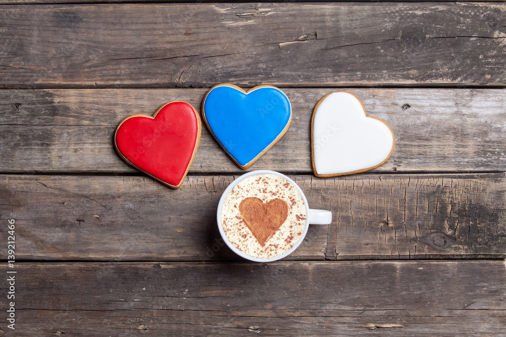 Fototapeta premium heart shaped cookies and cup of coffee on the wonderful brown wooden background