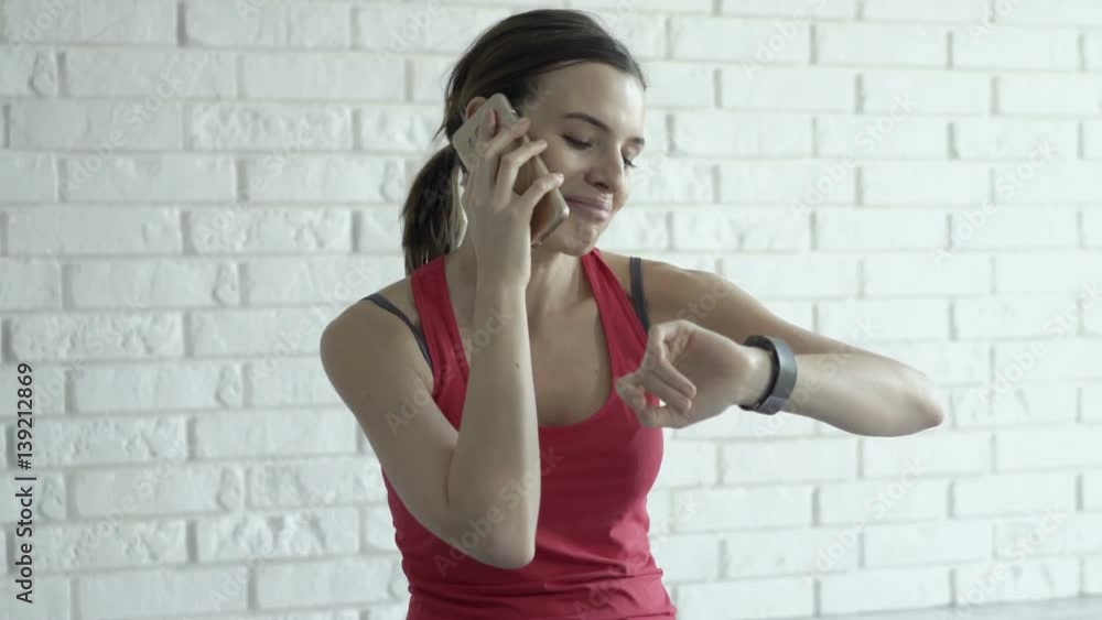 Young sporty woman talking on cellphone and checking smartwatch on mat at home
Young sporty woman talking on cellphone and checking smartwatch on mat at home