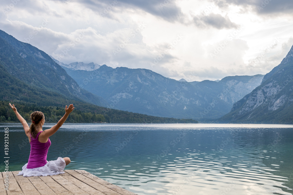 Woman meditating at the lake