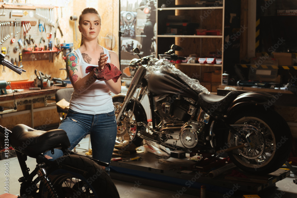 Obraz premium Serious girl with tattoo posing in workshop