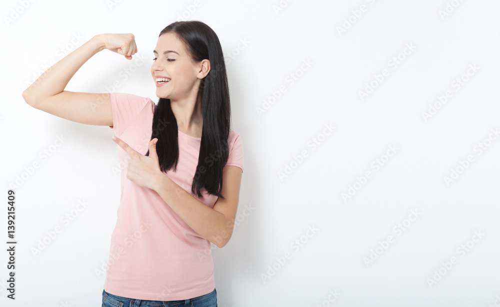 Sport. Strong woman. Beautiful girl showing her muscularity, looking at camera Sport. Strong woman. Beautiful girl showing her muscularity, looking at camera